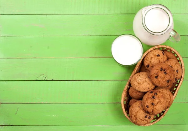 Sürahi ve bardak süt ile yulaf ezmeli kurabiye kopya alanı metniniz için yeşil bir ahşap zemin üzerine. Üstten Görünüm — Stok fotoğraf