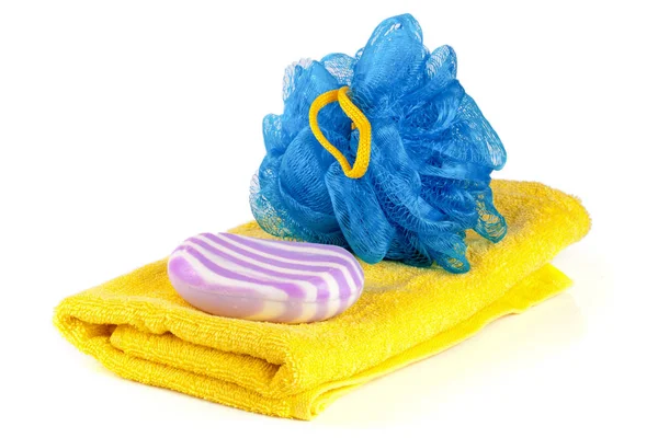 Toalha amarela com esponja de banho azul e sabão isolado no fundo branco — Fotografia de Stock