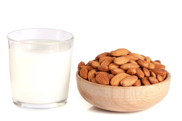 Lait d'amande dans un verre et amandes dans un bol en bois isolé sur un fond blanc — Photo