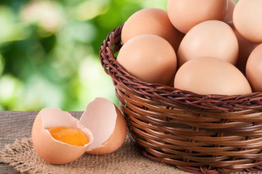 Bahçe arka plan bulanık ile ahşap bir gemide bir hasır sepet yumurta