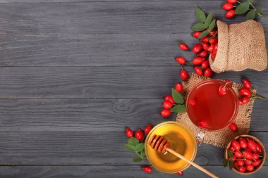 çay rose hips ve ballı kopya alanı metni siyah bir ahşap zemin üzerinde. Üstten Görünüm