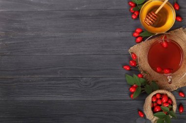 çay rose hips ve ballı kopya alanı metni siyah bir ahşap zemin üzerinde. Üstten Görünüm