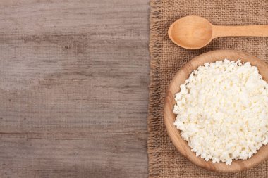 Ekşi krema kopya alanı metniniz için eski ahşap zemin üzerine ahşap bir kase süzme peynir. Üstten Görünüm