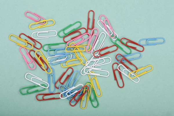 Colorful paper clips on green background. Top view — Stock Photo, Image