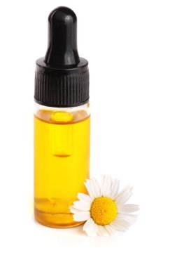 Beyaz arka planda özgün yağ ve taze papatya çiçekleri bulunan şişe.