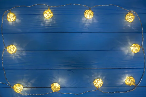 Christmas garland lights på blå trä bakgrund med kopia utrymme för din text. Ovanifrån — Stockfoto