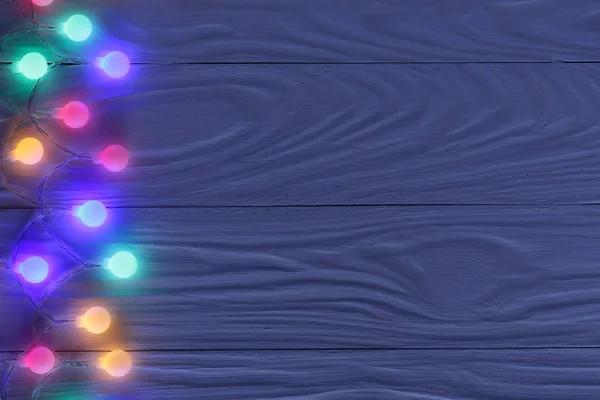 Χριστουγεννιάτικη γιρλάντα φώτα σε σκούρο φόντο ξύλινη με αντίγραφο χώρο για το κείμενό σας. Το Top view — Φωτογραφία Αρχείου