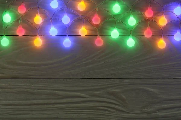 Ghirlanda di Natale luci su sfondo di legno scuro con spazio copia per il testo. Vista dall'alto — Foto Stock