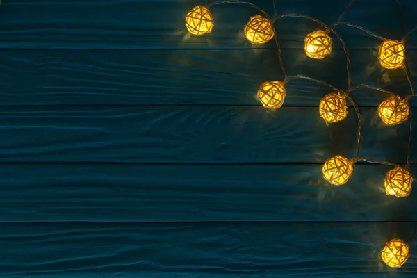 Luces de guirnalda de Navidad sobre fondo de madera azul con espacio de copia para su texto. Vista superior — Foto de Stock