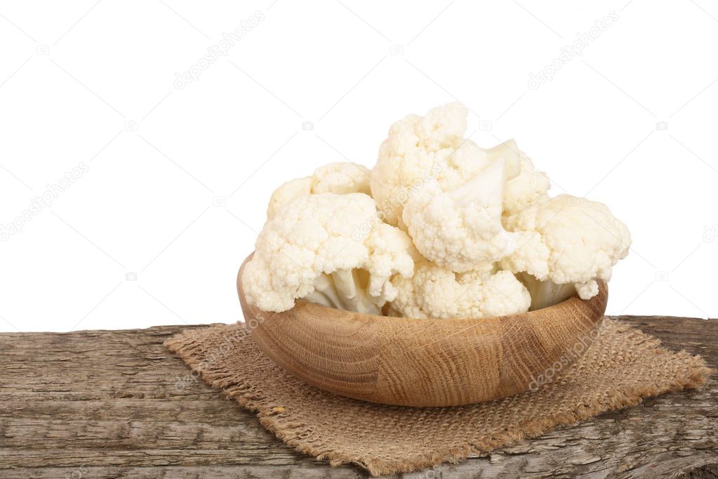 Piece of cauliflower in bowl on wooden table with white background