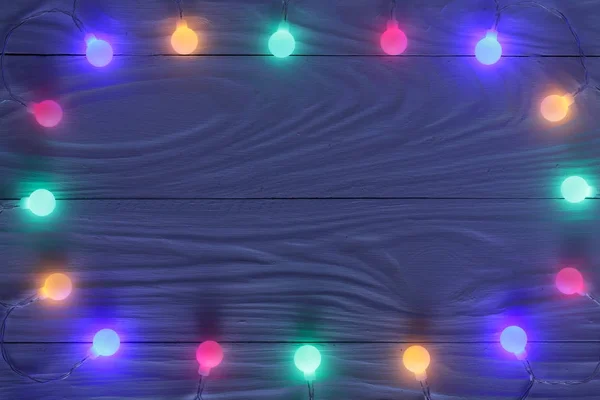Luces de guirnalda de Navidad sobre fondo de madera oscura con espacio de copia para su texto. Vista superior — Foto de Stock