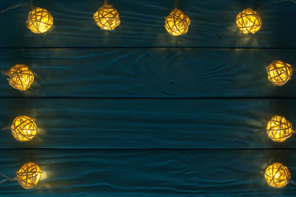 圣诞花环灯在蓝色木背景与复制空间为您的文本。顶部视图 — 图库照片