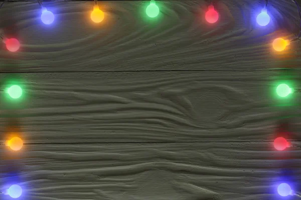 Різдвяні гірлянди вогні на темному дерев'яному фоні з копіювальним простором для вашого тексту. Вид зверху — стокове фото