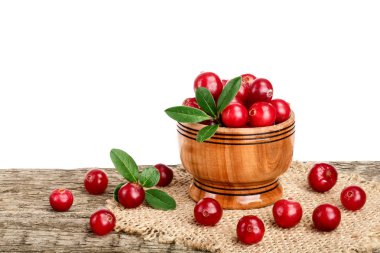 Cranberry with leaf in wooden bowl on old wooden table with white background clipart