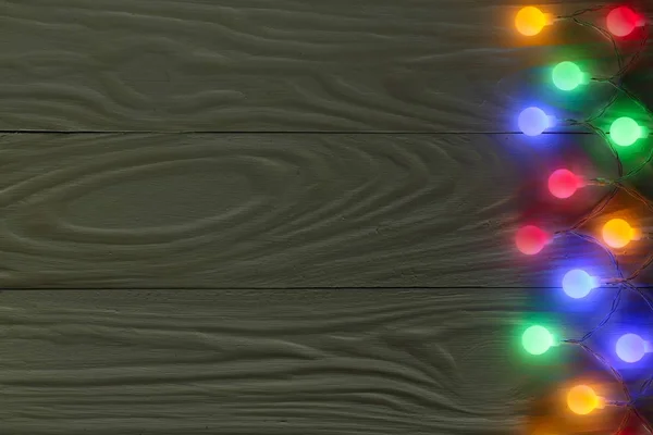 Boże Narodzenie świateł girlanda na ciemnym tle drewnianych z miejsca kopiowania tekstu. Widok z góry — Zdjęcie stockowe