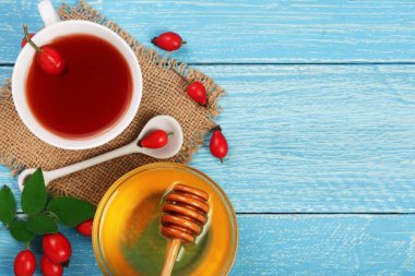 çay rose hips ve ballı kopya alanı metni mavi ahşap zemin üzerine. Üstten Görünüm