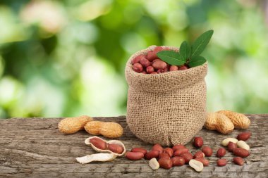 Fıstık çanta üzerinde eski bir bulanık Bahçe arka plan ile ahşap masa üzerinde yaprak ile