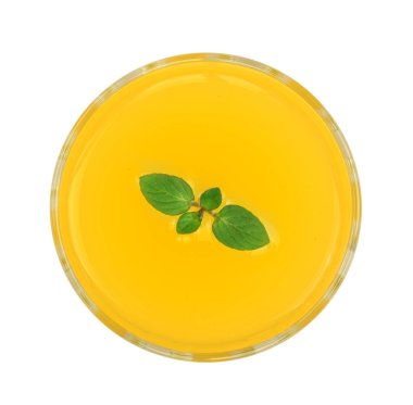 Beyaz arka plan üzerinde izole nane yaprakları ile bir bardak portakal veya ananas suyu. Üstten Görünüm