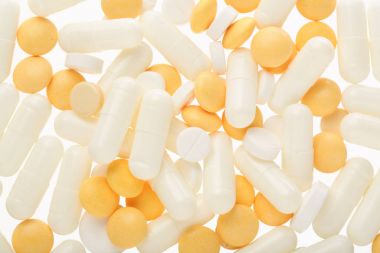 Beyaz arka plan üzerinde izole beyaz ve sarı hap kapsül. Üstten Görünüm. Düz yatıyordu