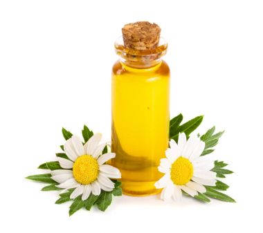 Beyaz arka planda özgün yağ ve taze papatya çiçekleri bulunan şişe.