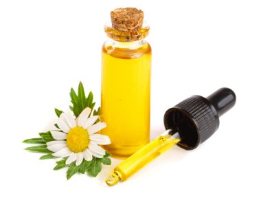 Beyaz arka planda özgün yağ ve taze papatya çiçekleri bulunan şişe.