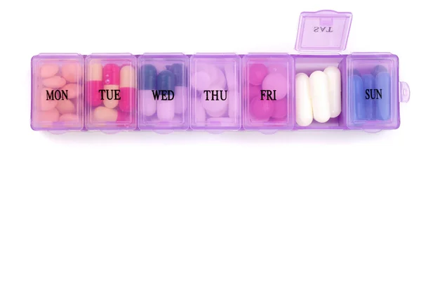 Caja de pastillas diaria con píldoras médicas aisladas sobre fondo blanco con espacio de copia para su texto. Vista superior. Puesta plana — Foto de Stock