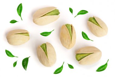 Pistachios decorated with leaves isolated on white background, top view. Flat lay clipart