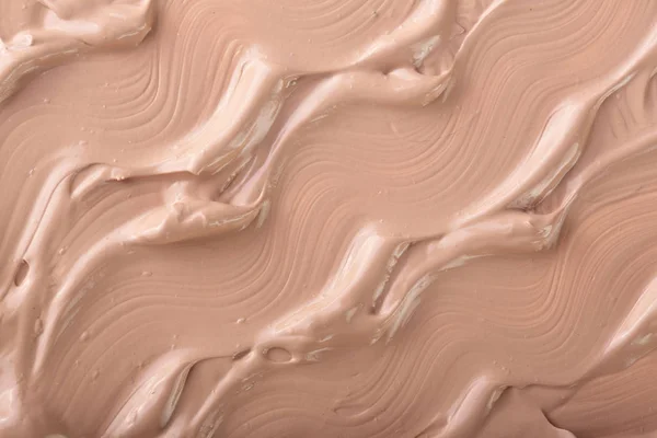 Beige liquid foundation makeup as a background. Top view. Flat lay pattern — Stock Photo, Image