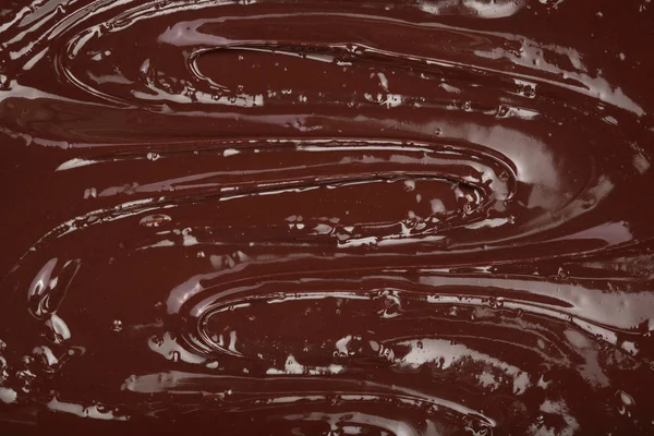 背景のクローズ アップとして溶かされたチョコレートを旋回 — ストック写真