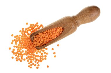 Ahşap Kepçe beyaz arka plan üzerinde izole içinde çiğ kırmızı mercimek yığını