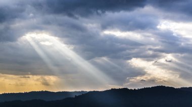 Günbatımı güneş Bulutların arasından parlıyor ile güzel mavi gökyüzü üzerinde
