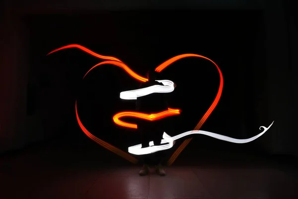 a neon lantern with a red heart on a black background