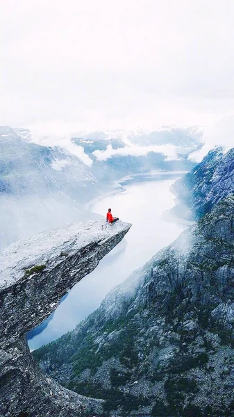 man in a jacket with a backpack on the top of the mountain