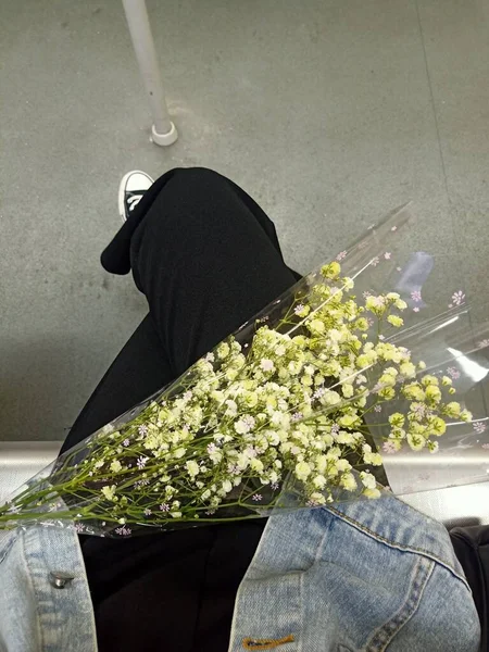 a man in a white shirt and a black dress with a bouquet of flowers