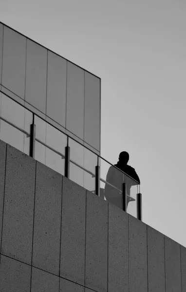 silhouette of a man in a black suit and a white shirt on a background of a building