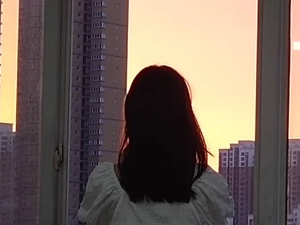 silhouette of a woman in a black dress with a window