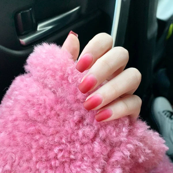 female hands with a pink manicure