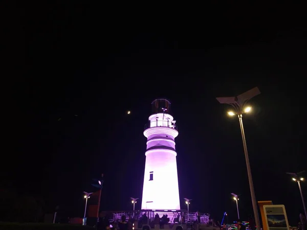 lighthouse at night, view from the sea, the moon, the sky and the light