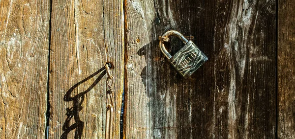 old rusty padlock on a wooden background