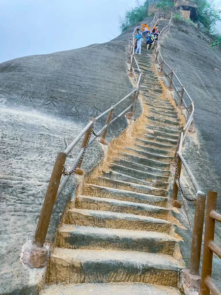 a man is walking on the stairs of the mountain.