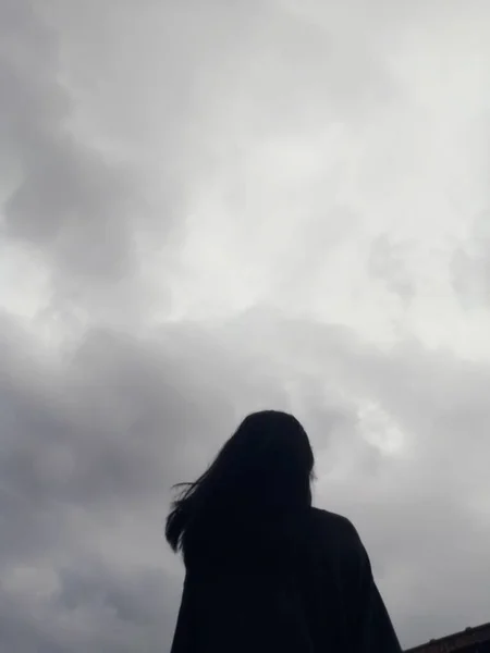 stock image silhouette of a woman with a backpack on the background of the mountains