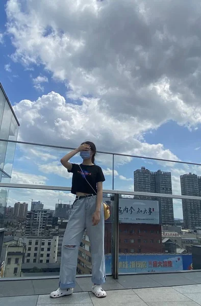 stock image young woman in casual clothes posing on the roof of the city