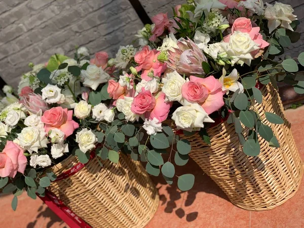 beautiful flowers in basket on a background of a wicker chair
