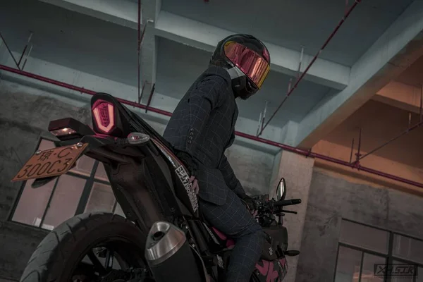 a man in a helmet and a motorcycle in the garage