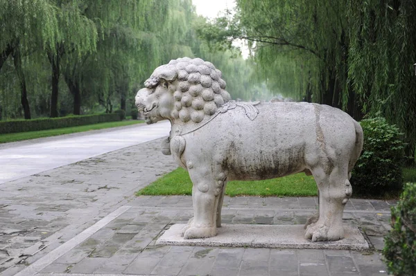 the statue of a lion in the park