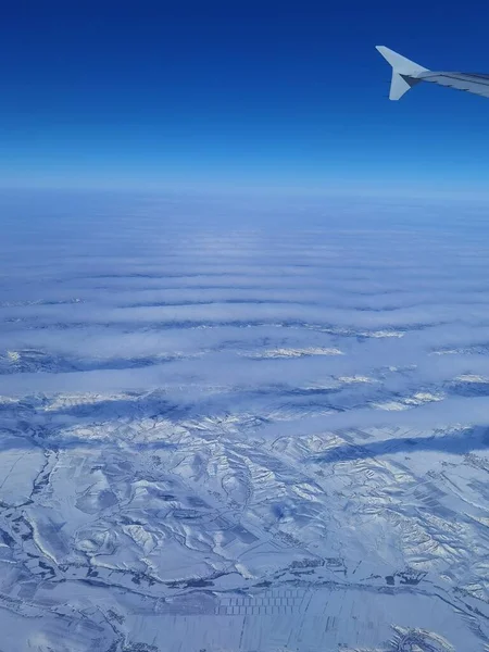 aerial view of the airplane flying over the earth.