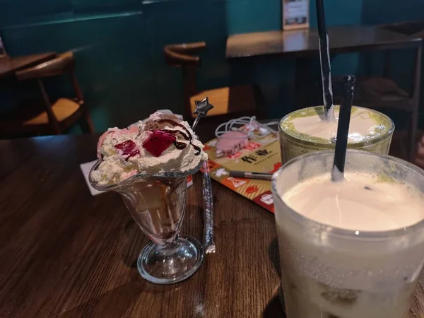 a glass of tea with ice cream and a cup of coffee