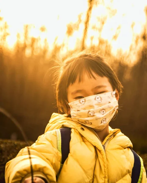 little girl in a protective mask and scarf