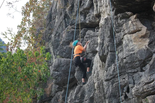 young woman climbing on the rock in the mountains