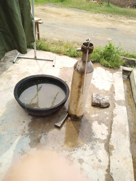 stock image a man is pouring water from a gas pipe.